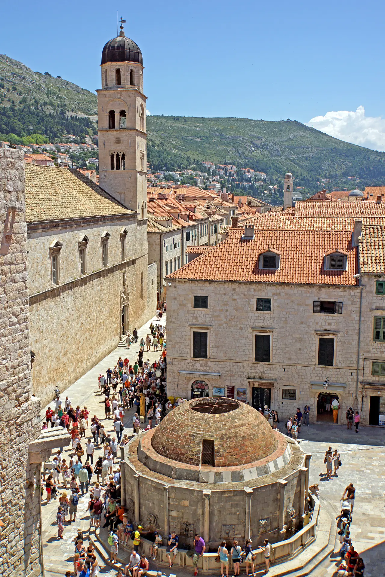 Big fountain in a city and people walking around