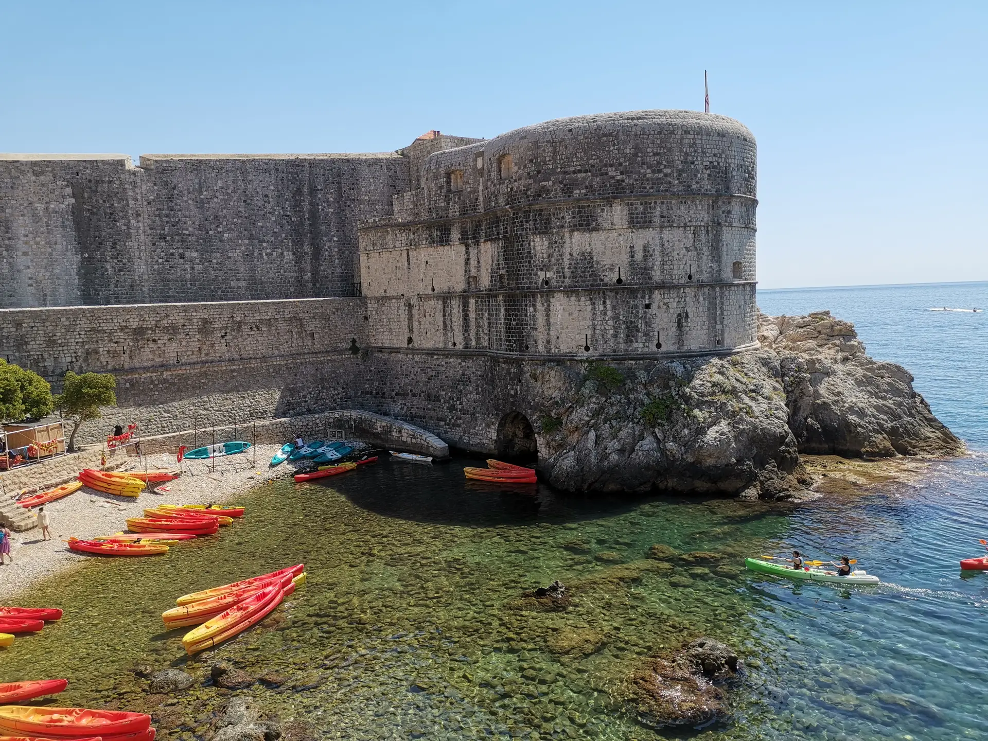 sea kayaks at a beach with fortress above