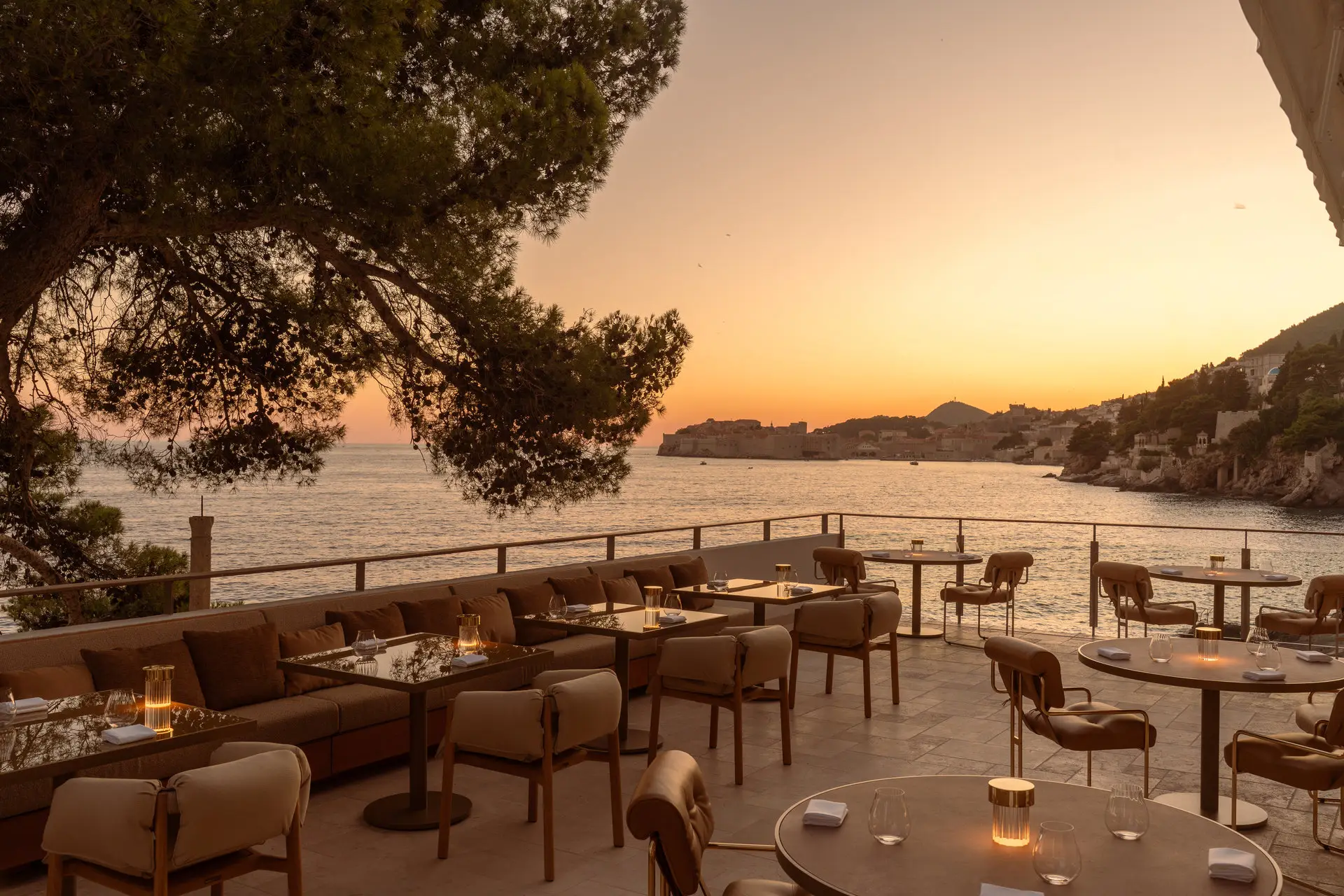 Terrace of a restaurant at sunset with panoramic view of a town
