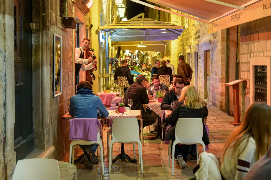 People eating dinner at restaurant by night